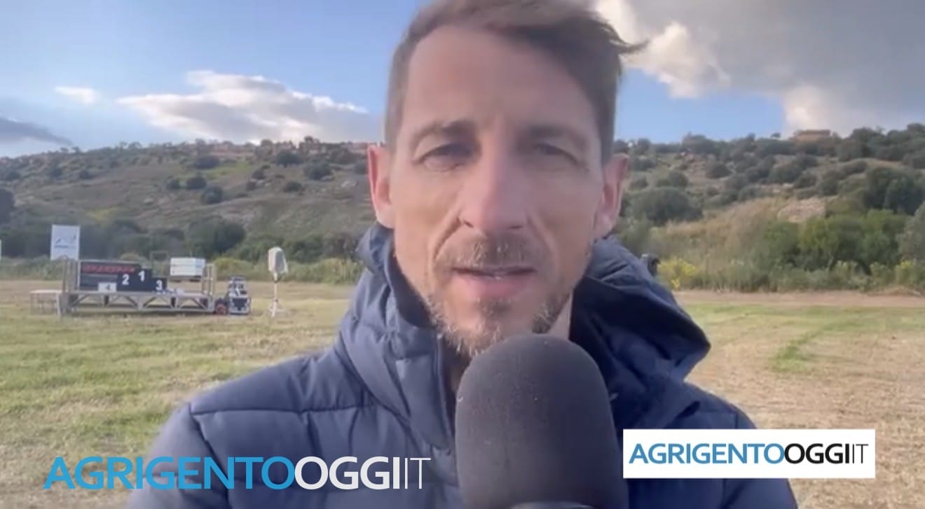 Intervista a bordo campo con il podio allestito sullo sfondo